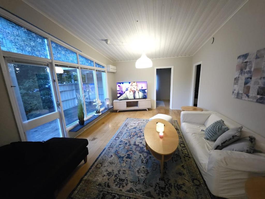 a living room with a white couch and a tv at Spacious villa in Sörby in Gävle