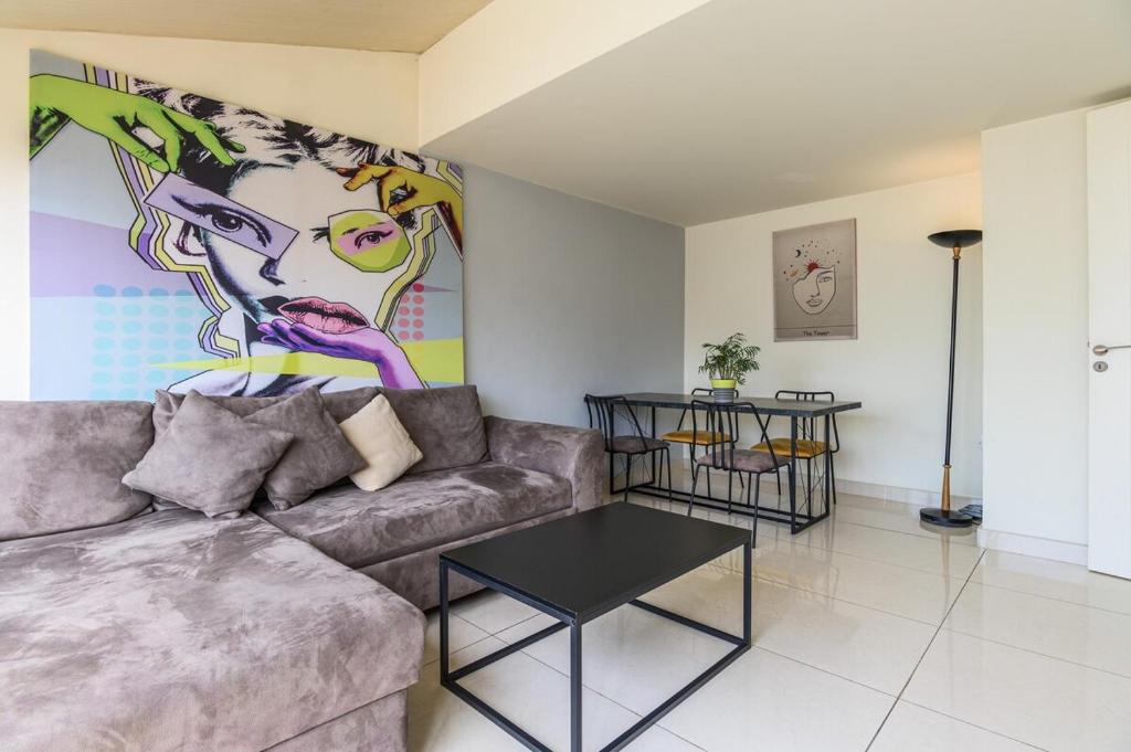 a living room with a couch and a painting at Rooftop one BDR with Terrace in Al Bawsharīyah