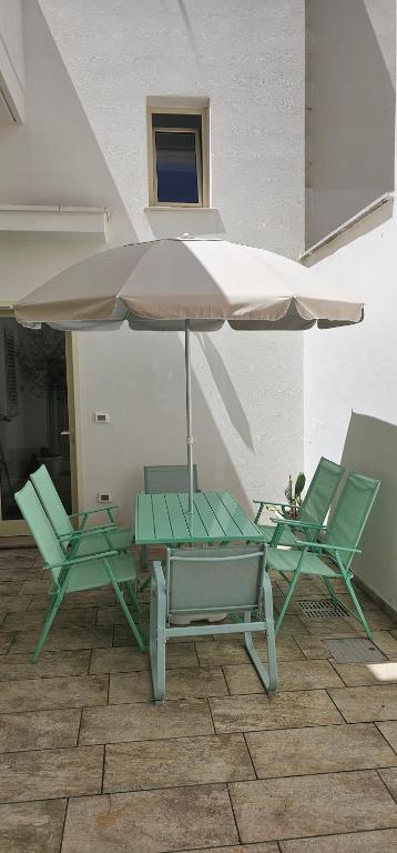 two chairs and a table with an umbrella at Mar Bello in Parabita
