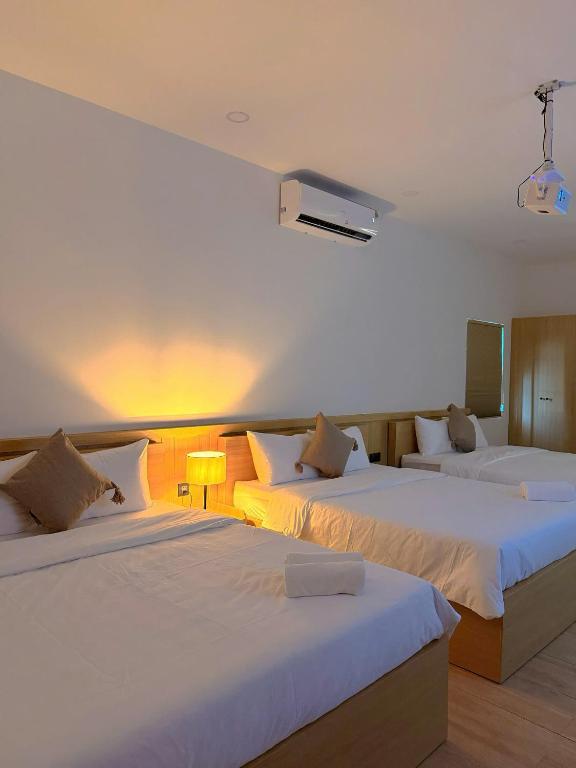 a hotel room with two beds and a light at Hue Glow Homestay in Thôn Lại Thê