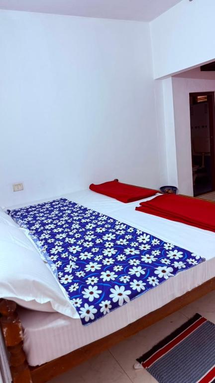 a bed with a blue and white blanket on it at Winter Flys in Anaviratty