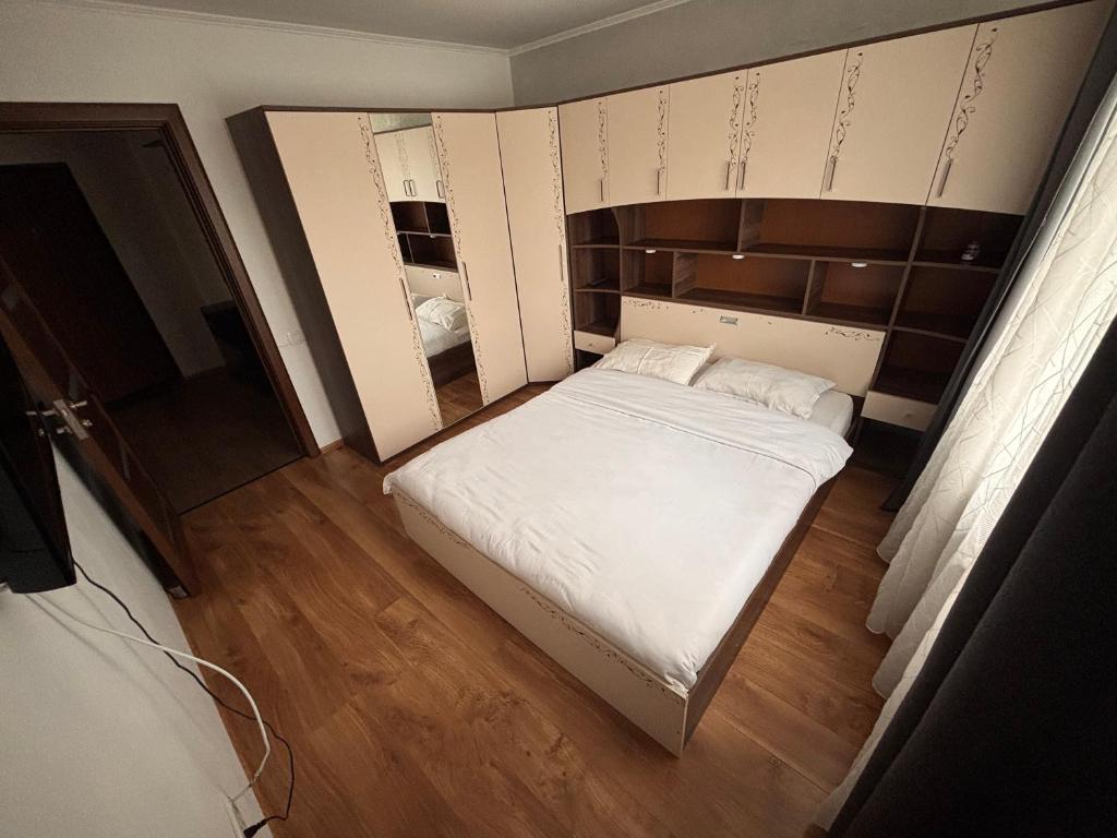 a small bedroom with a white bed and a mirror at Mio Apartments Silver in Cluj-Napoca