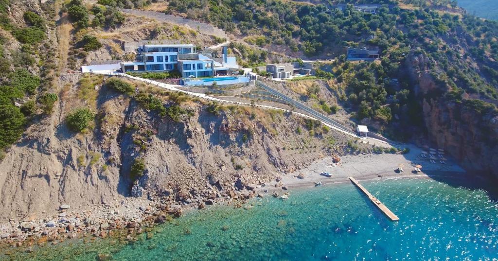 a house on a cliff next to a beach at The Cliff Residences in Plomari