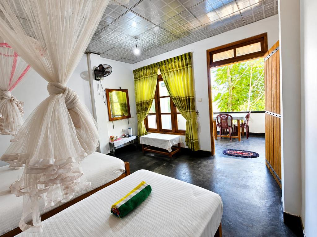 a bedroom with two beds and a room with a window at Enthral View Homestay in Ella