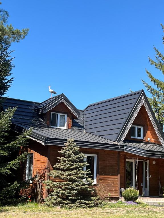 a brown house with a black roof at Pensjonat i domki Kresy in Pogorzelce