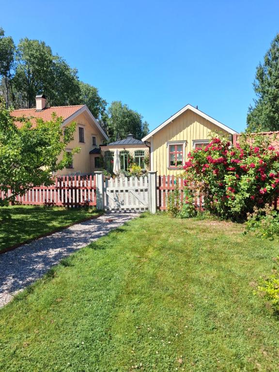 ein Haus mit Zaun und Garten in der Unterkunft Ängbacka in Rejmyre
