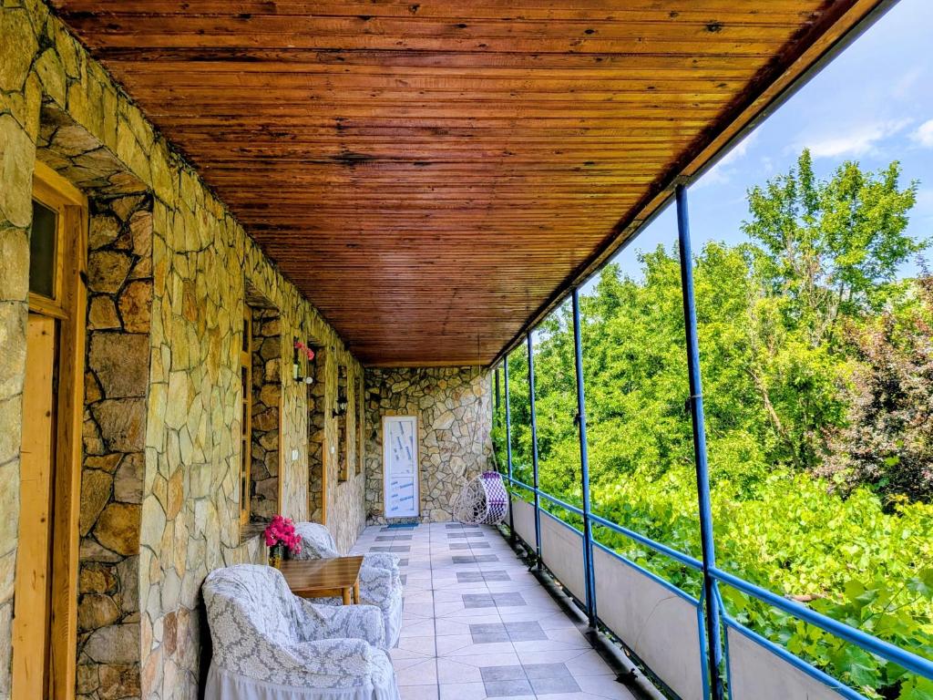 an outdoor porch with a wooden ceiling and windows at Sofia in Vardzia