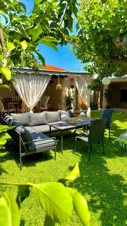 a garden with a couch and a table in the grass at Home Irianna in Marathon