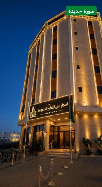 a tall building with a street sign in front of it at اسوار بلس - Aswar Plus in Tabuk
