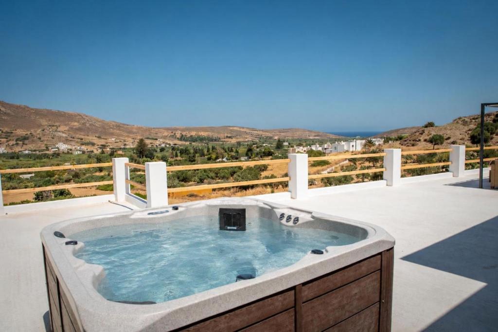 a jacuzzi tub on a patio with a view at Anthea Suites in Engares