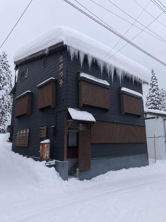 a house covered in snow with icicles on it at Edo-Ko House in Myoko