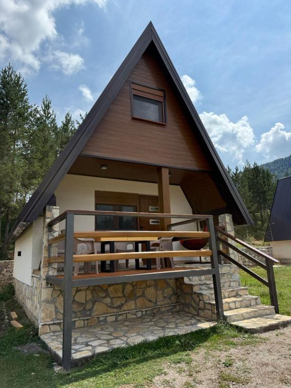 a small house with a gambrel roof at Zelena dolina Zminica in Zminica