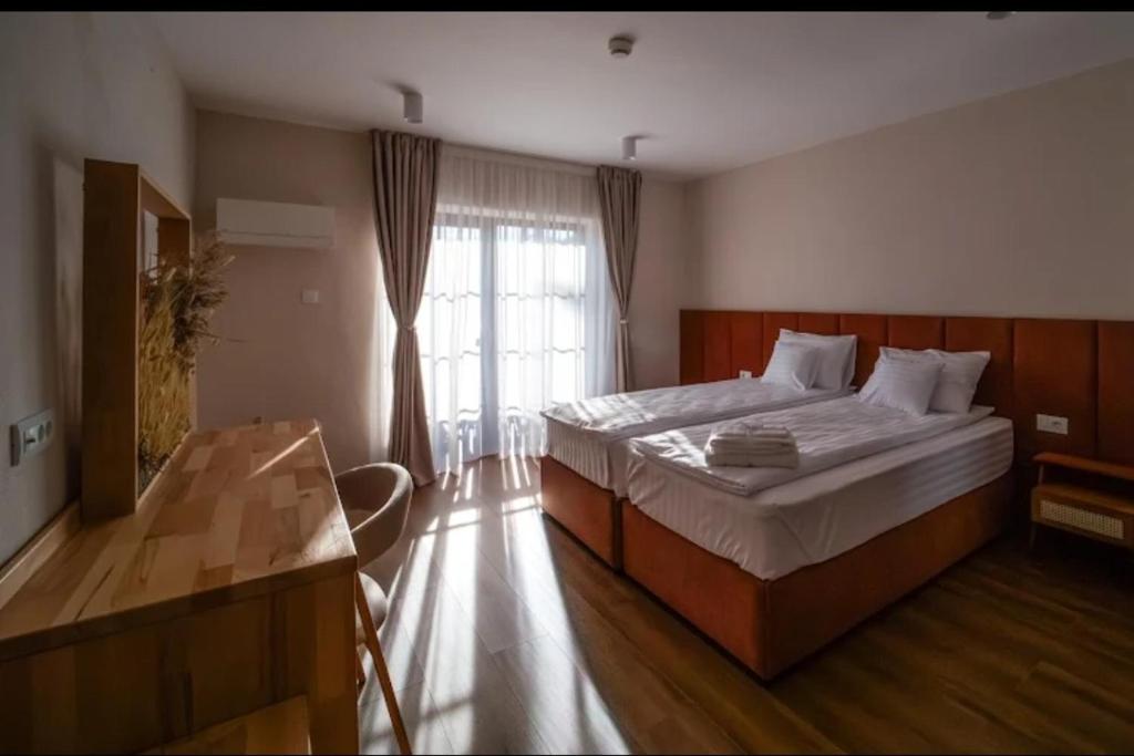 a bedroom with a large bed and a window at Hanul Pelerinului Cepari in Cepari Ungureni