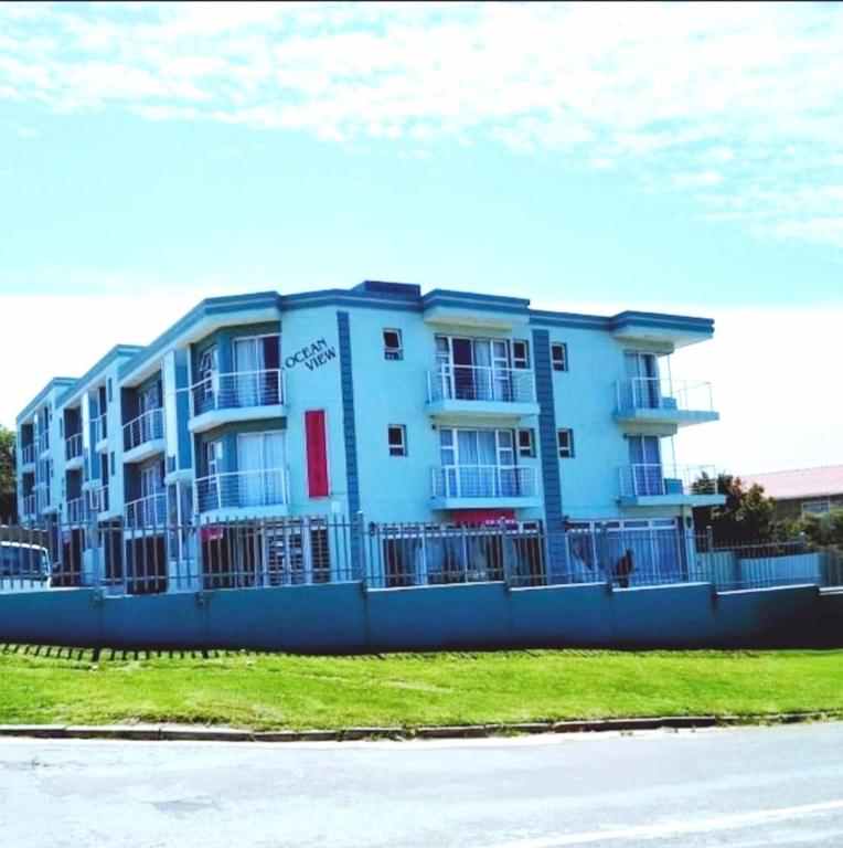 a blue building with a fence in front of it at Sea la vie at Jbay in Jeffreys Bay