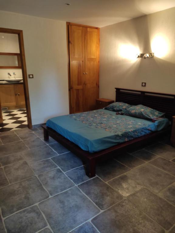 a bedroom with a bed and a tiled floor at Chambre d'hôte lozérienne in Saint-Privat-du-Fau