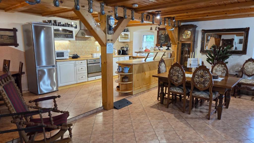 a kitchen with a table and a stainless steel refrigerator at Zacisze 13 in Leśna