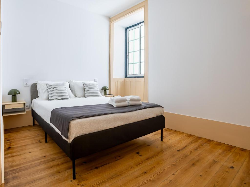 a bedroom with a bed and a large window at Sleep in Centre - Old Town in Aveiro