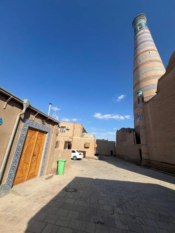 a building with a tower and a door and a street at Sobirjon Guest House in Khiva
