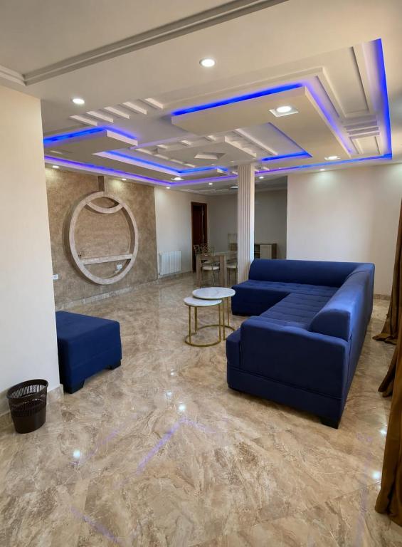 a lobby with a blue couch and a table at Perle de Soliman Plage in Soliman