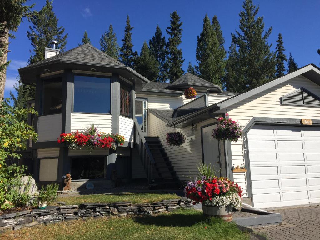 a house with a white garage and flowers in the yard at Bed & Breakfast Monarch in Canmore