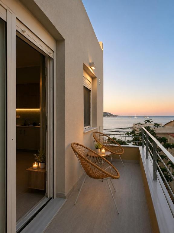 ein Balkon mit zwei Stühlen und Meerblick in der Unterkunft BluWave in Kómi