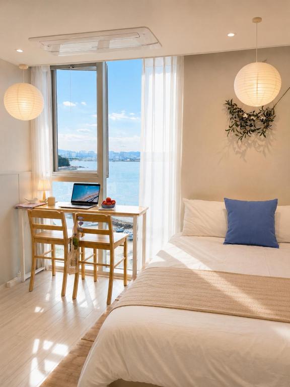 a bedroom with a bed and a desk with a laptop at Mood Ocean 인천 영종도 in Chagyak-to