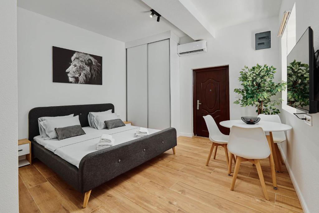 a bedroom with a bed and a table and chairs at Modern Studio Old Town by MN Property in Kotor