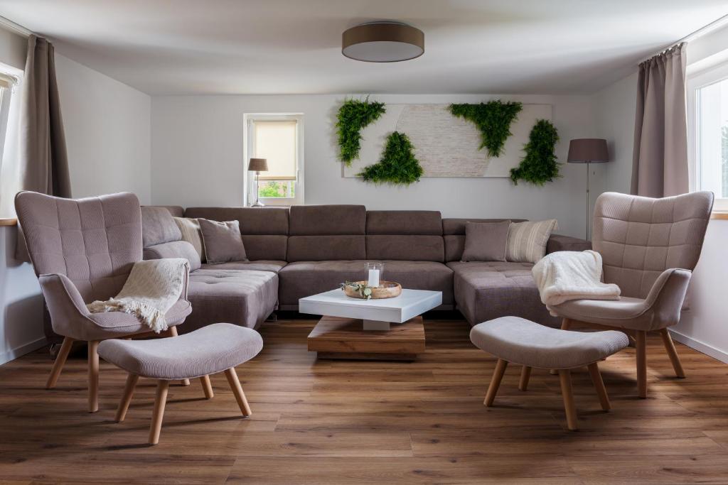 a living room with a couch and chairs and a table at Elbsandsteinlodge in Sebnitz
