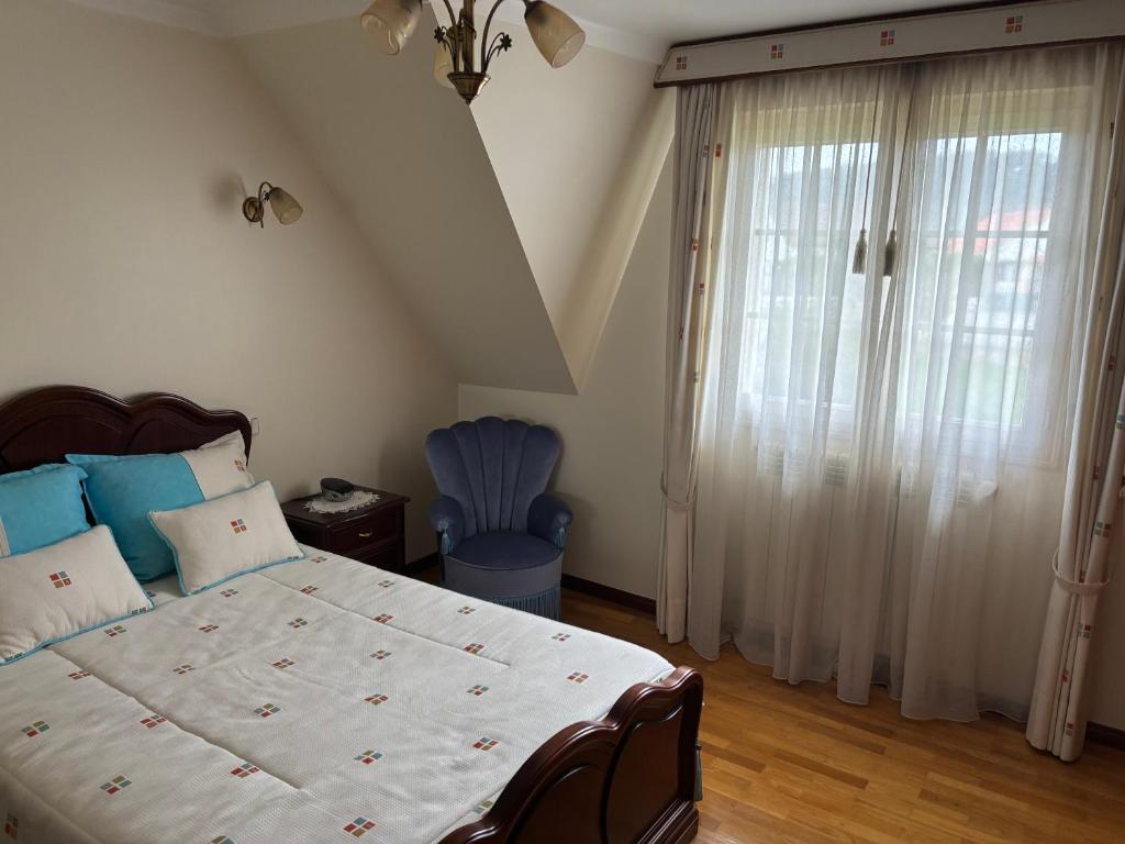 a bedroom with a large bed and a window at SERRA e MAR in Murtais