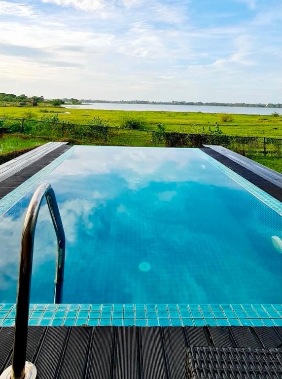 a large swimming pool with a view of the water at Blue Wild - Yala - Plastic Free & Sustainable in Tissamaharama