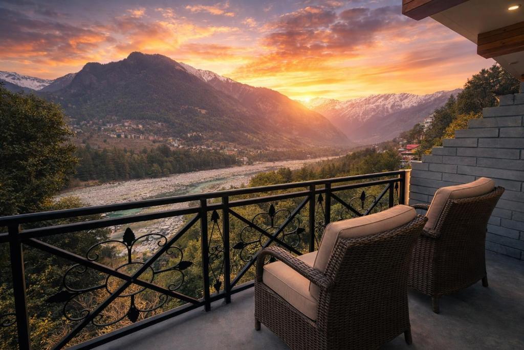 a balcony with two chairs and a view of a mountain at Hotel Hollywood Vibes #riverview #premium rooms #prime location #most awarded #parking #top rated #open terrace #lawn #best selling hotel in manali in Manāli