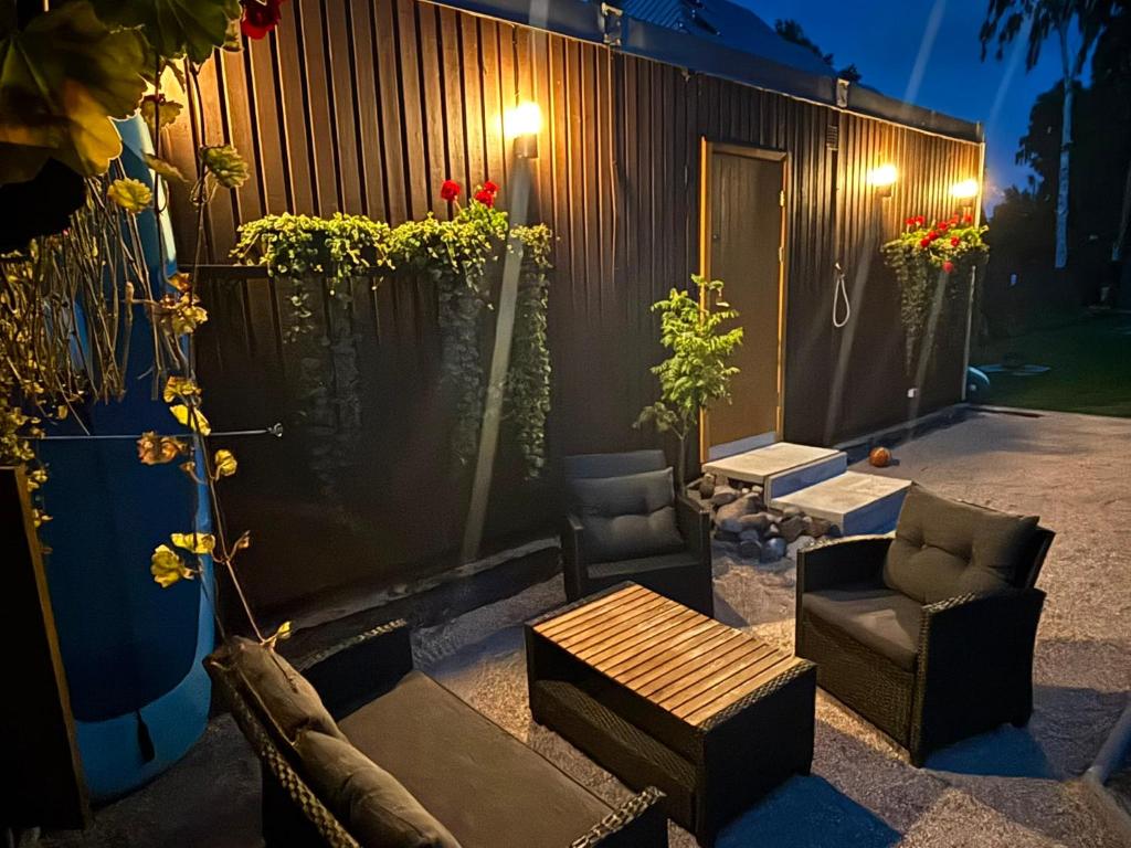 a patio with two chairs and a table and some plants at Namiņš in Ragaciems