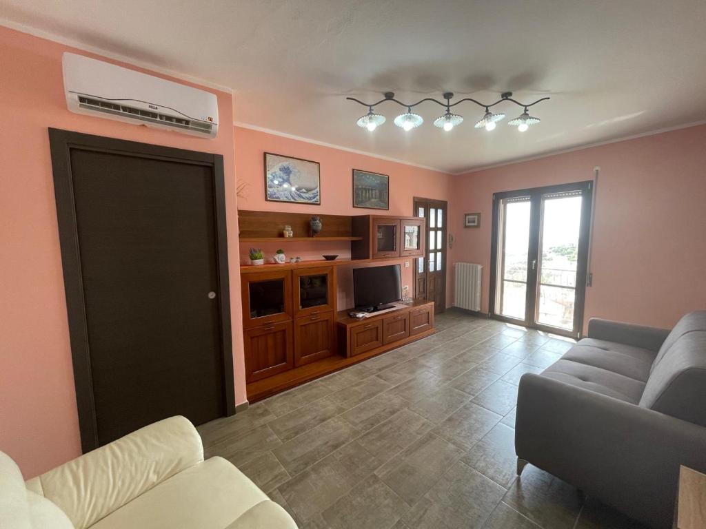a living room with a couch and a television at La Quiete dei Tacchi Ulassai in Ulassai