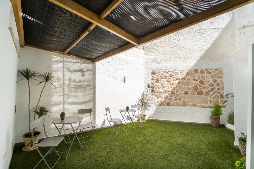 a patio with a table and chairs and a stone wall at La Siesta de Picasso in Málaga