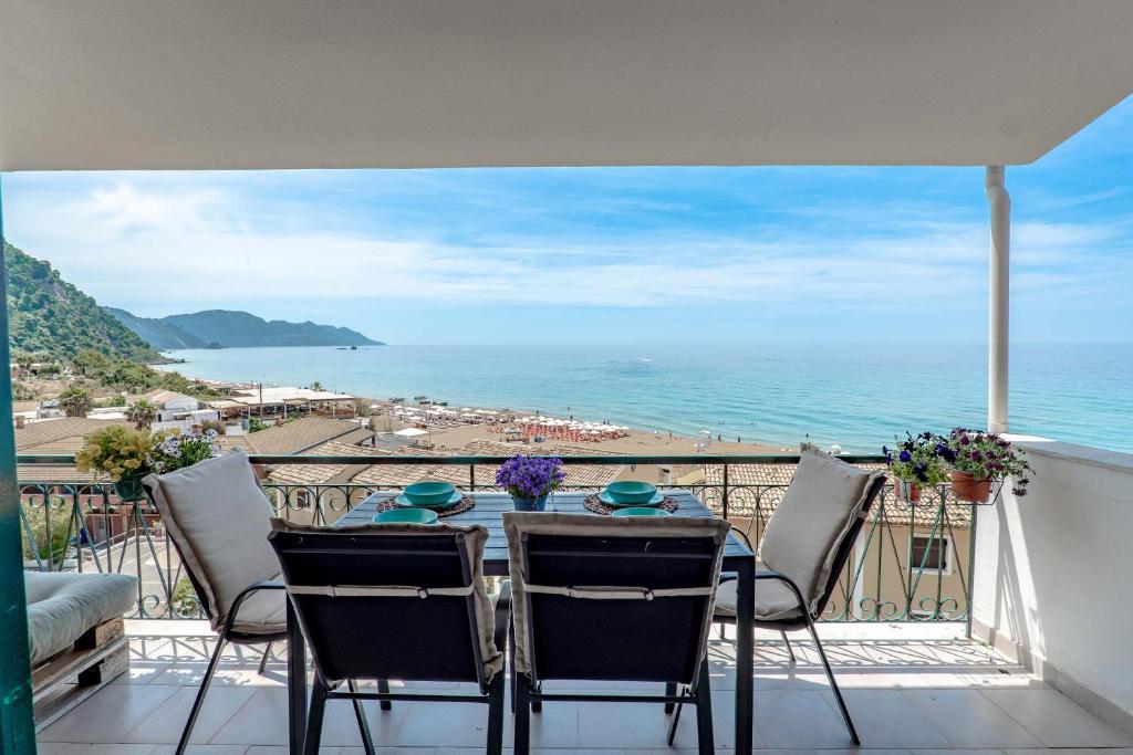 a table on a balcony with a view of the ocean at Corfu Dream Holidays Villas Standarts in Glyfada
