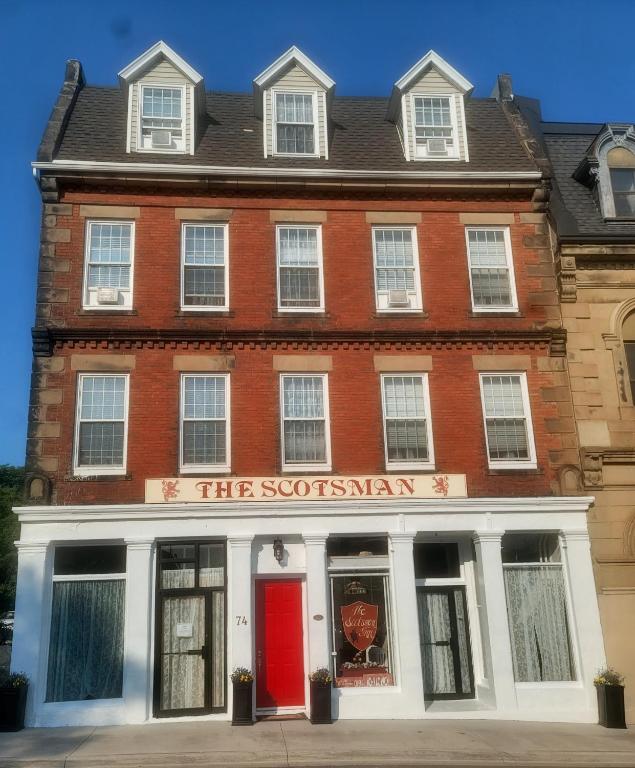 a red brick building with a red door at The Scotsman Inn in Pictou