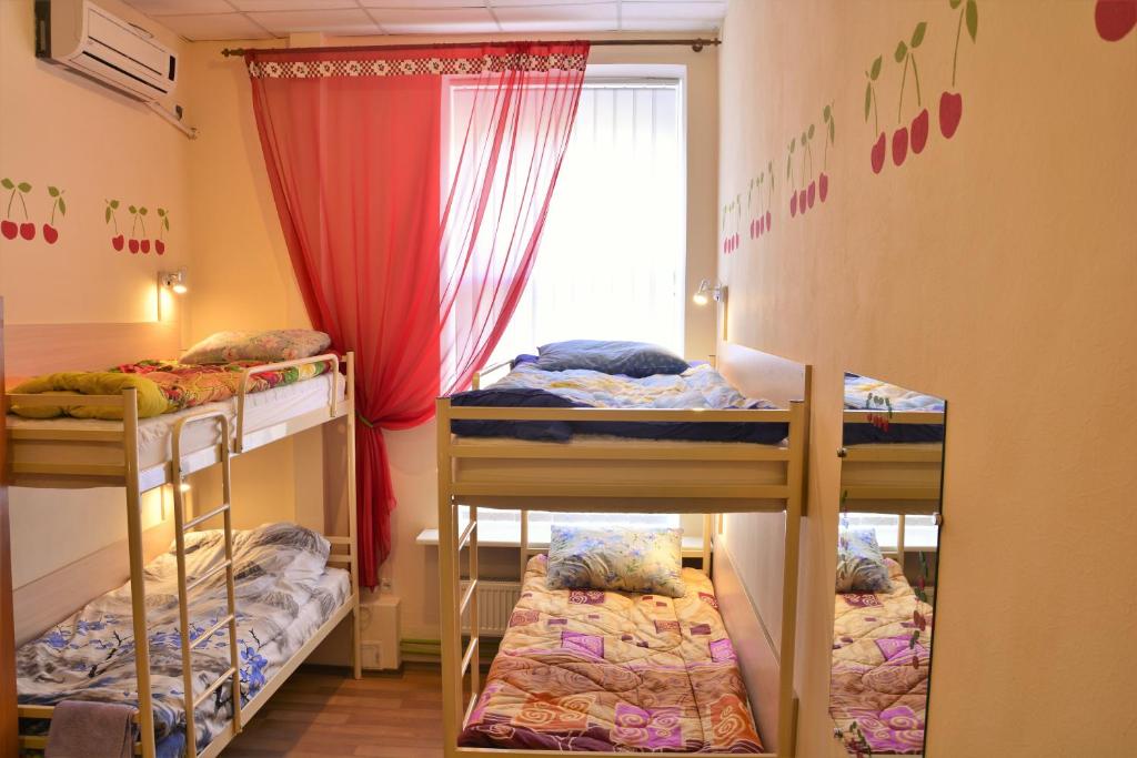 ドニプロにあるVishnya Hostelの二段ベッド3組、窓が備わる客室です。