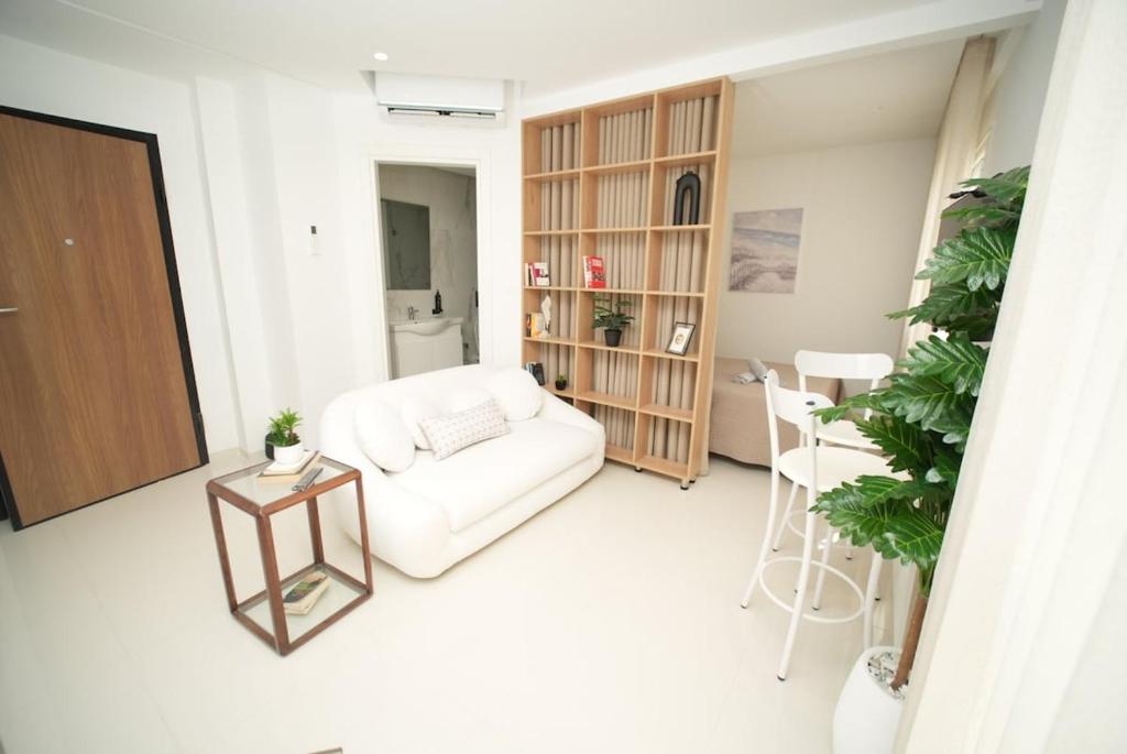 a living room with a white couch and a table at The Calm Coast Studio in Harqalah