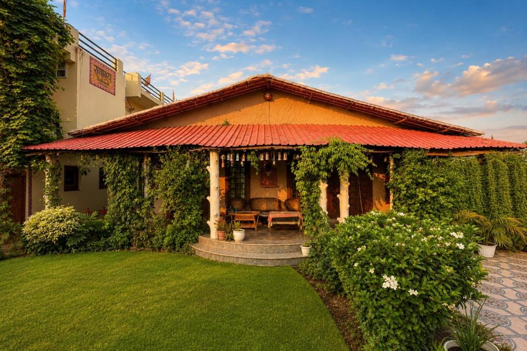 a house with a red roof and a green yard at Ramashray - Mud House Living in Haldwāni