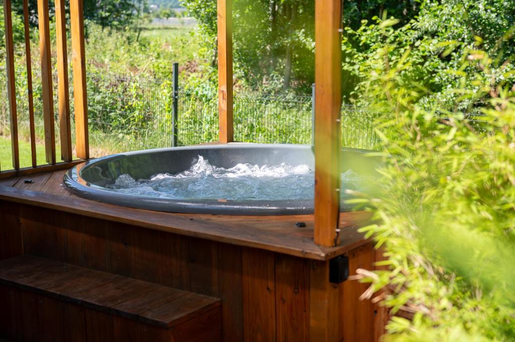 a hot tub sitting on a wooden deck at Osada Malawka pod Śnieżką - wypoczynek w saunie lub jacuzzi z widokiem na góry in Karpacz