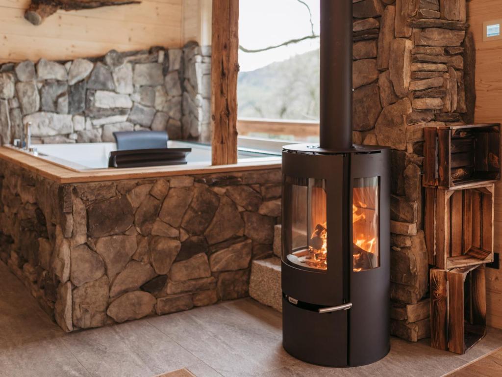 ein Ofen in einem Raum mit einer Steinmauer in der Unterkunft Romantikchalet Vogelnest mit Whirlpool, Kamin, Balkon & Terrasse in Vorra