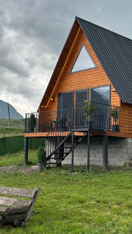 a log cabin with a deck and a porch at Lunara Chalet in Kazbegi
