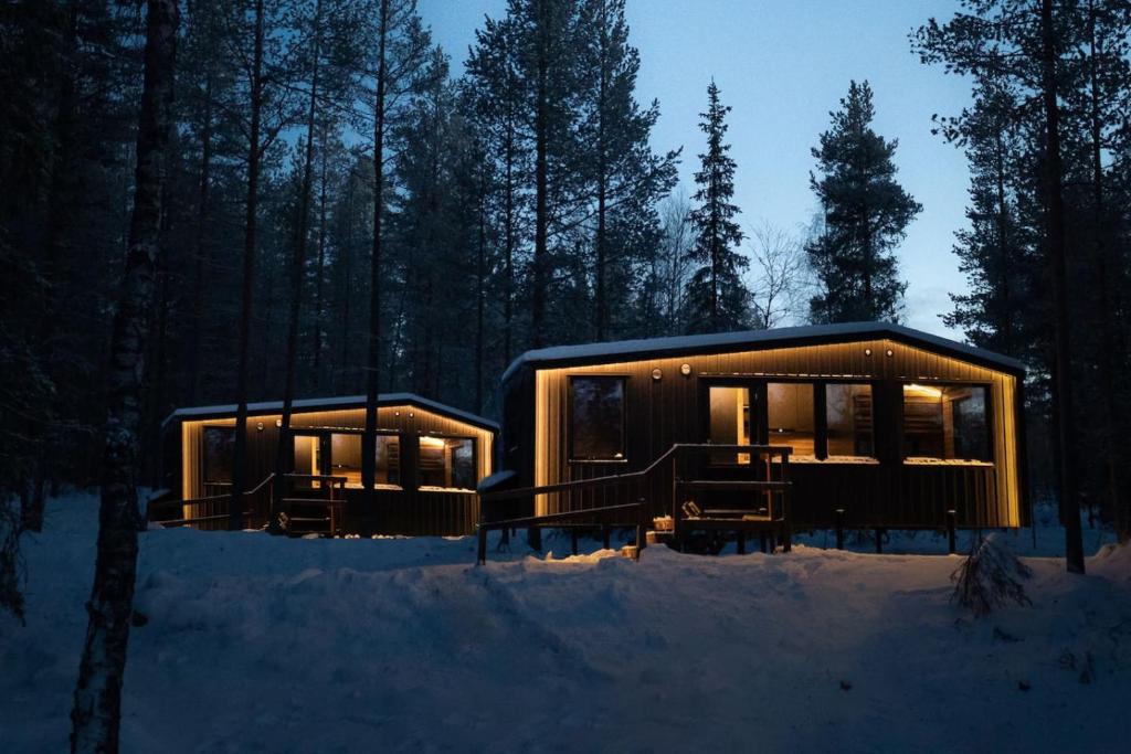 a cabin in the woods in the snow at night at Yllas Cabin for Work, Ski and Relax in Kolari
