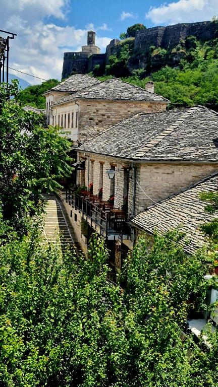 an old building with a balcony on a hill at 4 Rooms in Gjirokastër