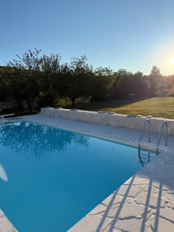 a blue swimming pool with trees in the background at Holiday Home “Vuko” in Trilj