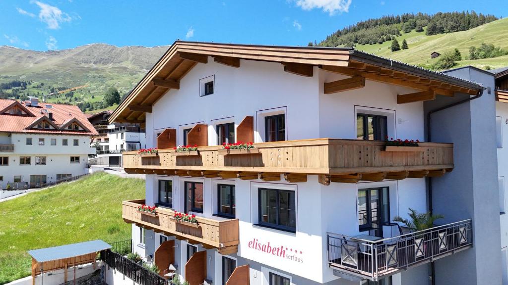 a white building with wooden balconies on it at Elisabeth Serfaus inkl der SUPER SOMMER CARD im SOMMER 2026 in Serfaus