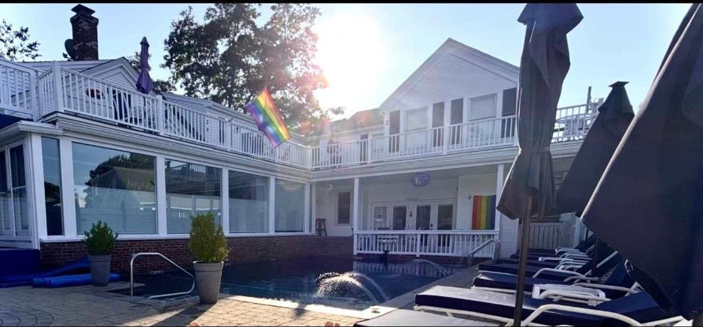 a large white house with a swimming pool with lounge chairs at Captivating Cottage in Provincetown