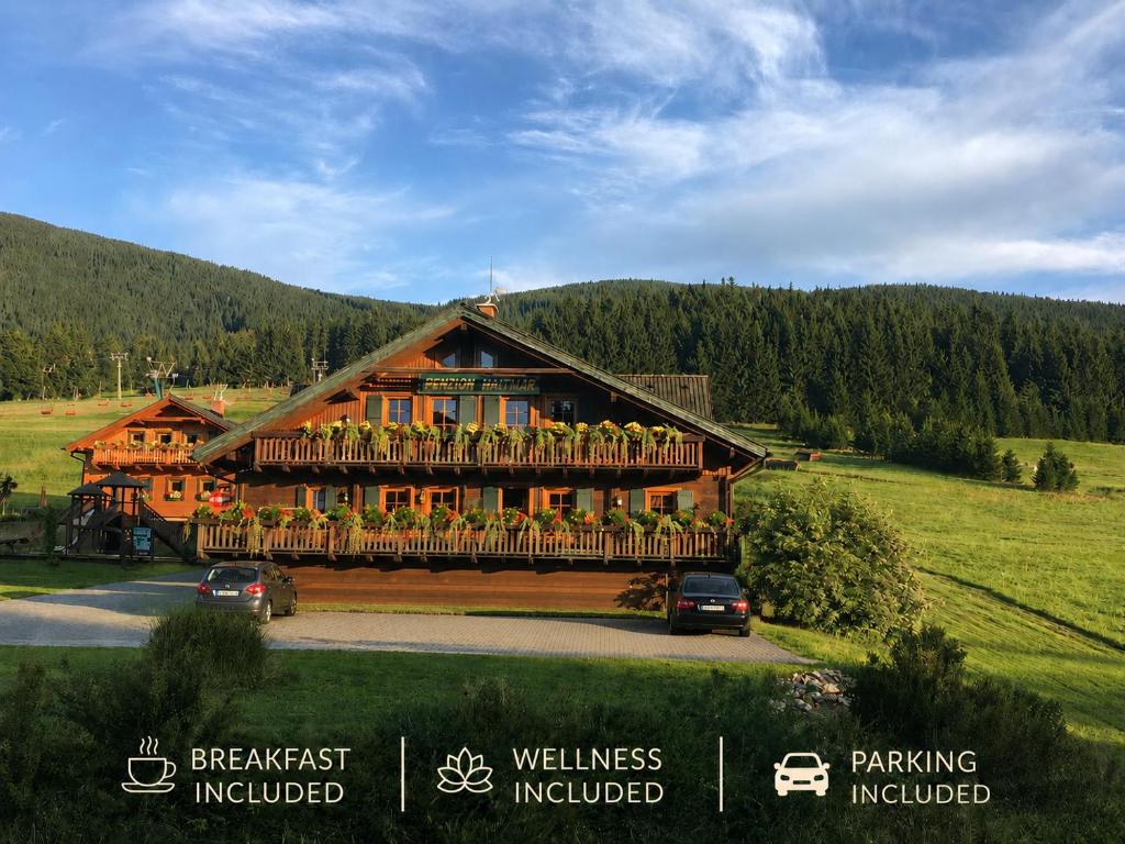 a large wooden house with a large balcony at Wellness Penzion Haltmar in Ramzová