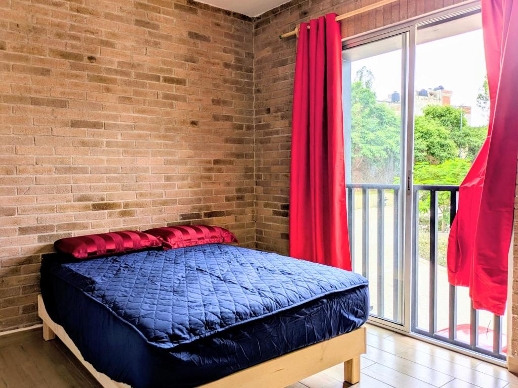 a bed in a room with a brick wall at Chepicche Inn in Oaxaca City