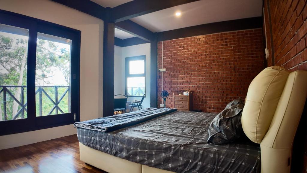 a bedroom with a bed and a brick wall at Samwise Escapade Hillside Guesthouse - Master Room in Kampong Perlis